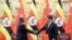 FILE - Ugandan President Yoweri Kaguta Museveni, left, shakes hands with Chinese President Xi Jinping during a signing ceremony in the Great Hall of the People in Beijing, March 31, 2015.