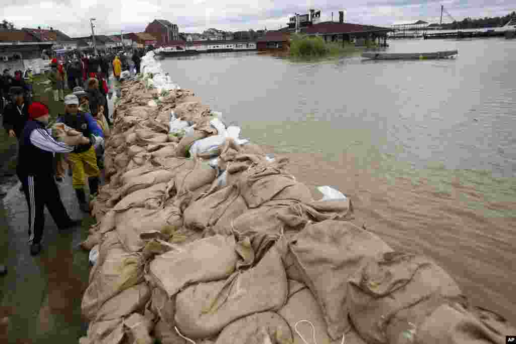 Warga membangun tanggul dari karung pasir di bantaran sungai Sava di Sremska Mitrovica, Serbia (17/5).&nbsp;(AP/Darko Vojinovic)