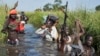 FILE - Rebel soldiers are seen protecting civilians from the Nuer ethnic group near Bentiu, South Sudan, Sept. 20, 2014. The arrival in Juba of South Sudan rebel leader Riek Machar’s forces is a crucial part to the implementation of the agreement signed last August.