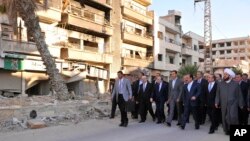 바샤르 알아사드 시리아 대통령(앞줄 가운데)이 12일 이슬람 명절 기도를 하러 반군으로부터 탈환한 모스크를 찾은 모습을 시리아 관영 매체가 공개했다. 