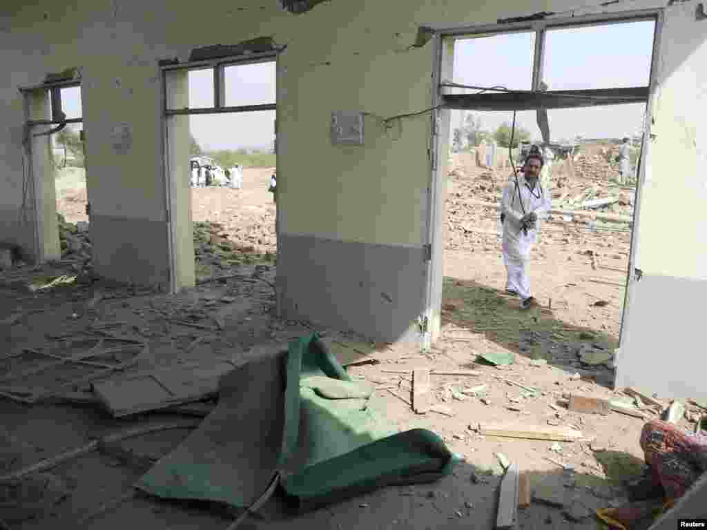 A member of the media walks past a damaged mosque at the site of a bomb attack in the Spin Tal region of Hangu district, Pakistan, Oct. 3, 2013.
