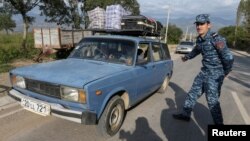 নাগর্নো-কারাবাখ অঞ্চলের উদ্বাস্তুরা এক আর্মেনিয়ান চেকপয়েন্টে গাড়িতে বসে আছেন। ২৪ সেপ্টেম্বর, ২০২৩।