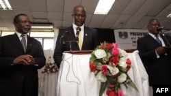 Malawi’s presidential aspirant in the May 20 tripartite elections and head of Malawi's United Democratic Front (UDF) party Atupele Muluzi (C) speaks next to his running mate Godfrey Chapola (L) and a Malawi Electoral Commission official (R) to present hi