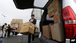 来自朝鲜开城的韩国工人2013年4月9日抵达板门店村边界附近的海关，移民和检疫局之后搬运货物纸箱。