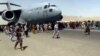 Stotine ljudi trči duž piste pored američkog vojnog transportnog aviona C-17, dok se on kreće na Međunarodnom aerodromu "Hamid Karzai" u Kabulu 16. avgusta 2021. (Foto: AP)