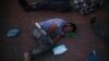 FILE - A migrant who returned from the U.S. the previous day sleeps outside a Mexican immigration office in Matamoros, Mexico, Aug. 4, 2019, on the border with the U.S.