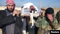 Para pejuang lasykar pembebasan Suriah mengangkut komandan mereka yang tewas di kota Qusair, provinsi Homs (25/3). Pertempuran meningkat selama dua pekan terakhir di kota ini. 