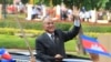FILE-Cambodia's King Norodom Sihamoni waves from a vehicle to students during the Independence Day celebrations in Phnom Penh, Cambodia, Monday, Nov. 9, 2015.