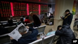 5일 중국 베이징의 증권거래소에서 투자가들이 증시 변동 상황을 지켜보고 있다.