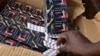 FILE - A policeman shows counterfeit medicine tablets during a police raid against shops selling fake medicine and counterfeit drugs on May 3, 2017 at the Adjame market in Abidjan. 