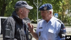 네덜란드(오른쪽)와 호주 경찰이 27일 우크라이나 도네츠크에서 대화를 하고 있다. 