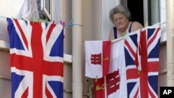 Photo d’archives: Une résidente de Gibraltar arborant par sa fenêtre les drapeaux du Royaume Uni et de Gibraltar, le 4 août 2004. Les habitants de la colonie britannique, qui ont massivement voté pour le "Remain", sont inquiets des conséquences d'une sortie de la Grande-Bretagne de l'Union européenne.