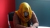FILE - A female TV presenter from southern Afghanistan conceals her identity for security reasons as she is being interviewed by the Associated Press in Kabul, Afghanistan, Feb. 3, 2021.