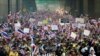 Waving flags and placards, Thai anti-government protesters make their way on a street during a march rally from the government complex on the outskirts of the capital to downtown Bangkok, Thailand, Dec. 9, 2013.