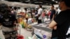 Warga memborong bahan makan di sebuah supermarket di Singapura karena khawatir terjadi kelangkaan setelah Malaysia mengumumkan penutupan perbtasan untuk mengatasi virus corona, 17 Maret 2020. (Foto: Reuters)