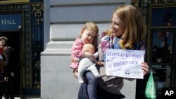 Kim Tarner nosi ćerku Adelajd na skupu podrške inicijativi o plaćenom odusustvu za roditelje novorodjene dece. 