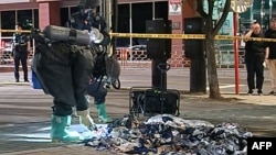 韩国国防部发布照片显示，韩国军方人员在首尔街头检查据信是朝鲜释放的气球带来的不明垃圾物品。（2024年6月2日）