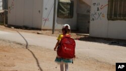 Une fille se rend à l'école dans le camp de réfugiés de Zaatari pour les réfugiés syriens, dans le nord de la Jordanie, le 6 août 2017.