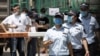 Workers leave from a coronavirus testing center set up outside a sports facility in Beijing, Tuesday, June 16, 2020. China reported several dozen more coronavirus infections Tuesday as it increased testing and lockdown measures in parts of the…