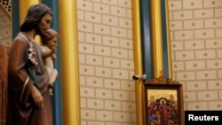 资料照片：北京西什库天主教教堂内一幅宗教画作旁安装的监控摄像机。 (2019年12月24日)