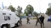 Congolese Revolution Army (CRA) rebels walk past a United Nations patrol truck parked along a street in Goma in the eastern Democratic Republic of Congo (DRC), November 20, 2012.