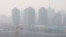 FILE - A construction site is seen against the backdrop of skyscrapers on a day with high air pollution in Beijing, China, March 11, 2021. 