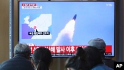 한국 서울역에서 시민들이 북한이 미사일로 추정되는 발사체를 발사했다는 보도를 시청하고 하고 있다. 