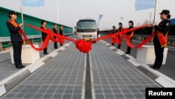 山东济南的光伏高速公路亮相，巴士在公路上（2017年12月28日）。中国央视说，这是由中国“完全自主知识产权研发与铺设的全球首段光伏高速公路”，“目前，半透明的路面已铺设完毕，一些车辆已经开始在路面上进行测试。 ”