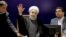Iranian President Hassan Rouhani (C) waves after registering for February's election of the Assembly of Experts, at the Interior Ministry in Tehran, Dec. 21, 2015.