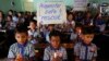 FILE - Students at a school in Ahmadabad, India, hold candles and pray for the Thai youth soccer players and their coach trapped in a cave, July 9, 2018.