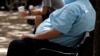 FILE - A heavyset man rests on a bench in Jackson, Miss., Sept. 4, 2014.