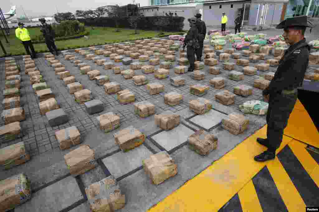 Polisi anti-narkoba berjaga di dekat paket ganja sitaan di kantor polisi di Bogota, Kolombia. Polisi Kolombia menyita sekitar 6 ton ganja selama operasi anti narkoba 22 April 2013.