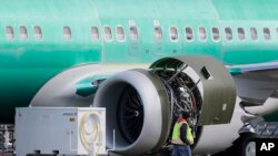 Seorang pekerja melintas mesin sebuah Boeing 737 MAX 8 yang tengah diproduksi untuk maskapai American Airlines di fasilitas perakitan milik Boeing Co. di Renton, Washington, 13 Maret 2019 (foto: AP Photo/Ted S. Warren)