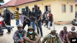 FILE - Three men, front, identified as kidnappers of Bethel Baptist High School students, are shown to the media in Abuja, Nigeria, Sept. 23, 2021. Arrests were made in the abduction for ransom of 121 students from the school in northern Kaduna state.