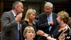 VIsoka predstavnica EU Ketrin Ešton razgovara sa italijanskom ministarkom spoljnih poslova Federikom Mogerini i njenim švedskim kolegom Karlom Biltom na sastanku ministara EU u Briselu.