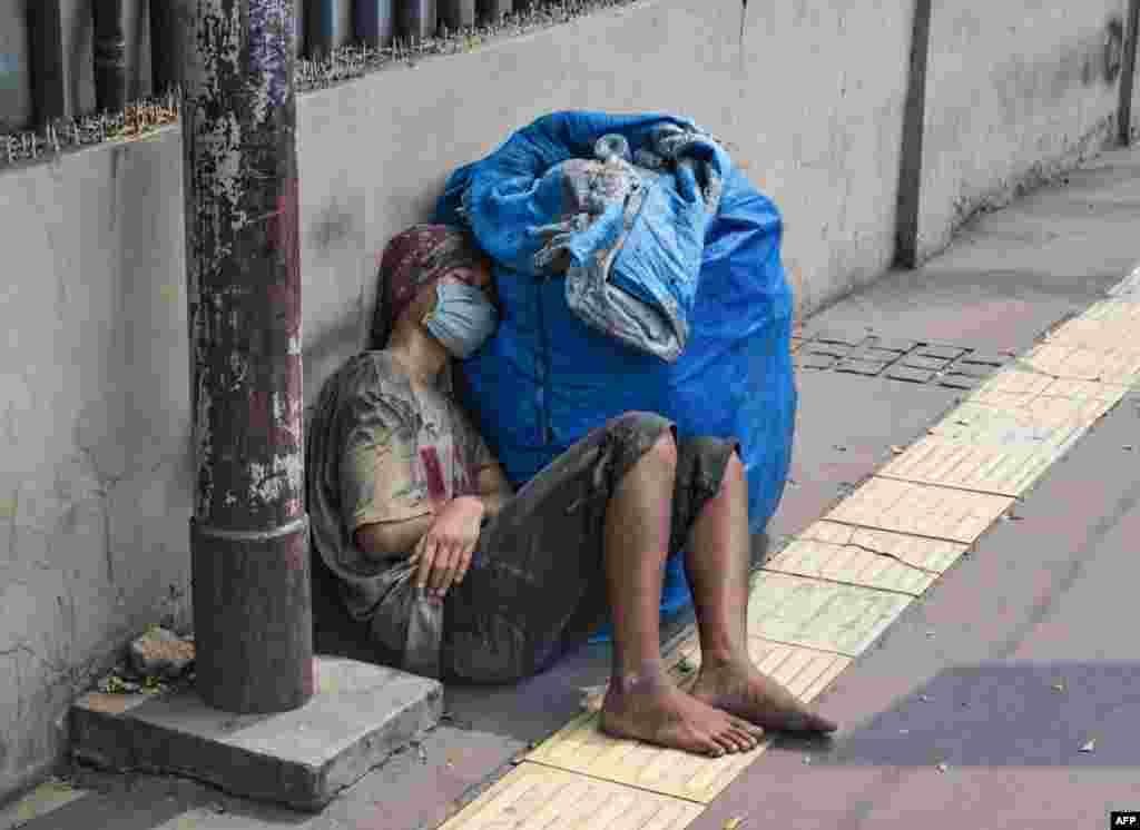 A man takes a nap on the pavement in downtown Jakarta.