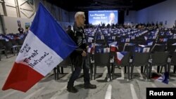 A supporter holds a French flag before a political rally of Marion Marechal-Le Pen, French National Front political party candidate for the second round of regional elections in Marseilles, Dec. 9, 2015.