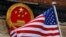 FILE - An American flag is flown next to the Chinese national emblem during a welcome ceremony for visiting U.S. President Donald Trump outside the Great Hall of the People in Beijing, Nov. 9, 2017.