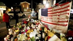 Bendera Amerika dan daftar korban penembakan massal menghiasi sudut kota Newtown, Connecticut (20/12). (Foto: AP)