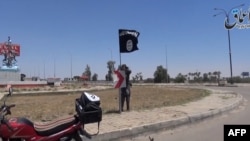 Youtube一段视频截图显示，一名伊斯兰国武装分子据称在拉马迪的街道上挂起伊斯兰国的旗子 （2015年5月18日）