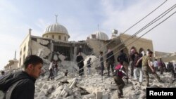 Warga dan anggota Tentara Pembebasan Suriah memeriksa mesjid Bilal di Marat al-Numan, dekat propinsi Idlib (24/10).