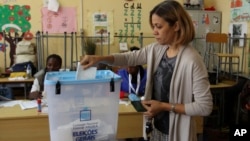 A voter casts her ballot in elections in Luanda, Angola, Aug. 23, 2017.