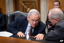 资料照片：参议院外委会主席、民主党参议员梅嫩德斯(左)与外委会资深成员、共和党参议员里施在一次有关援助乌克兰抗击俄罗斯的听证会上交谈。(2022年5月12日)
