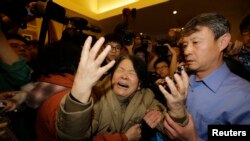 Seorang anggota keluarga penumpang Malaysia Airlines penerbangan MH370 menangis setelah melihat konferensi pers pemerintah Malaysia di hotel Lido, Beijing (24/3). (Reuters/Jason Lee)
