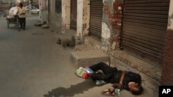 In this Oct. 31, 2019, photo, an Indian drug user lies unconscious by the side of a road in Kapurthala, in the northern Indian state of Punjab. Mass abuse of the opioid tramadol spans continents, from India to Africa. (AP Photo/Channi Anand)