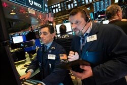 Traders monitor stock prices at the New York Stock Exchange, Jan. 2, 2020.