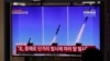 FILE: People watch a TV screen airing reports about North Korea's firing missiles with file images of missiles at the Seoul Railway Station in Seoul, South Korea, April 14, 2020.