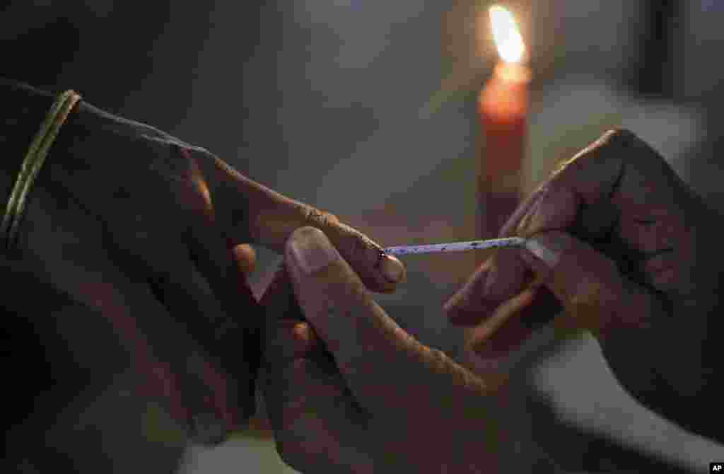 An election official applies an indelible ink mark on the finger of a Mishing tribal woman voter in Misamora Sapori, an island in northeastern Assam state, India, April 7, 2014.