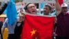 FILE - Uighurs living in Turkey and Turkish supporters, chant slogans as they hold a Chinese flag before burning it during a protest near China's consulate in Istanbul, against what they call oppression by Chinese government to Muslim Uighurs in far-western Xinjiang region, July 5, 2015. 