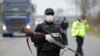 FILE - Police officers check motorists on a road access point to Tandarei, eastern Romania, April 4, 2020, after authorities imposed a severe quarantine status on the city.